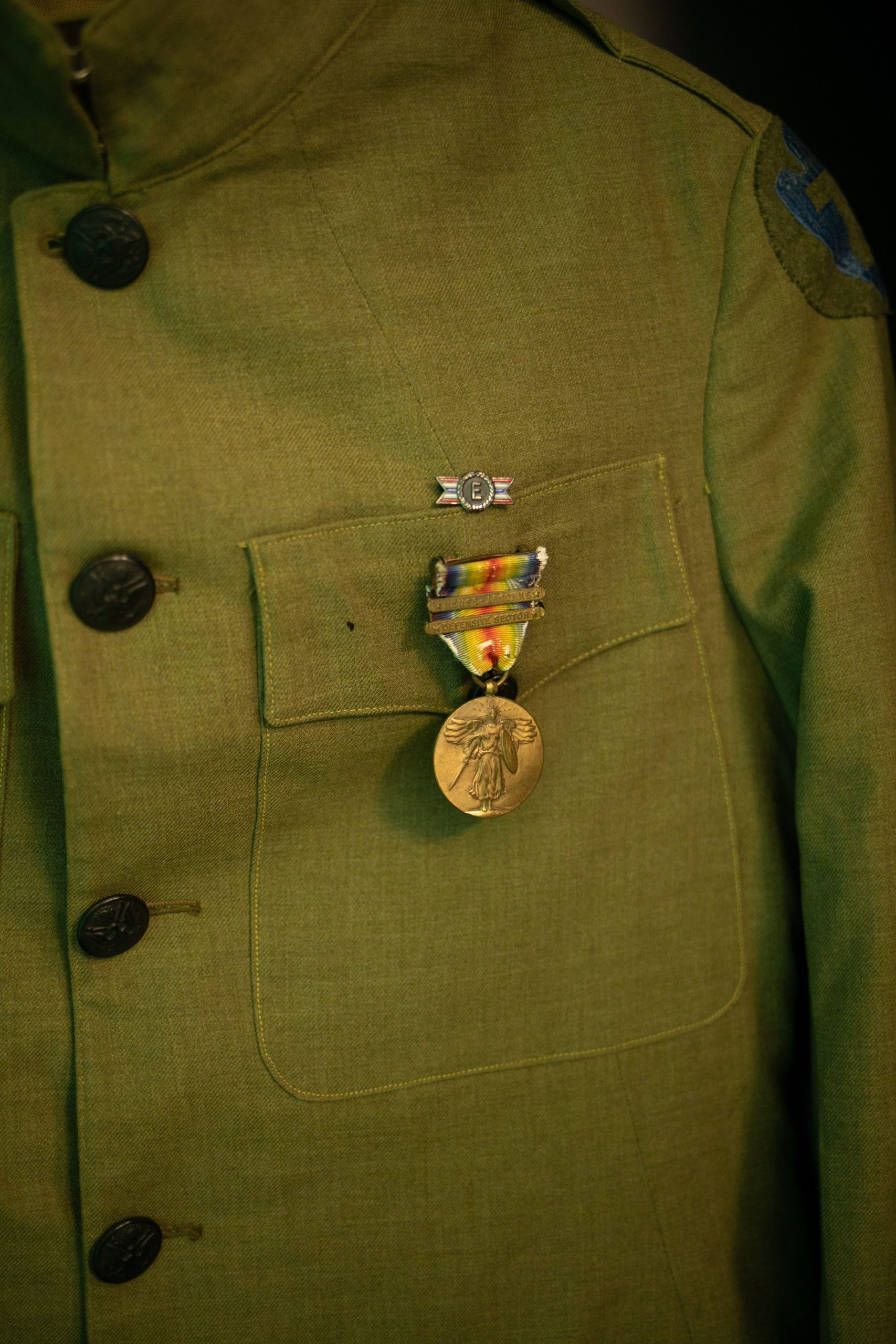 A uniform with a medal. The image is zoomed in on the coat pocket.